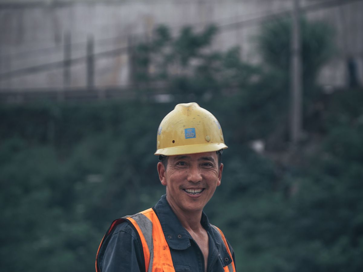 Smiling Filipino construction worker in a hard hat and high-visibility vest on a Saudi Arabia worksite